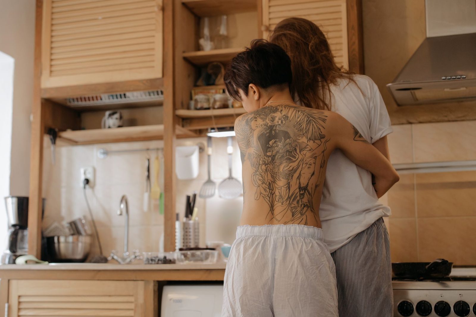 Um casal compartilha um abraço íntimo em sua cozinha acolhedora e convidativa, refletindo amor e conexão