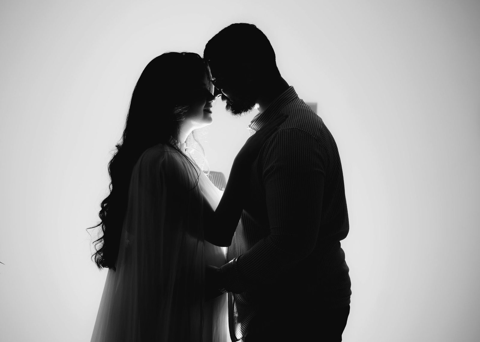 Silhueta de um casal se abraçando com uma luz de fundo, simbolizando amor e intimidade