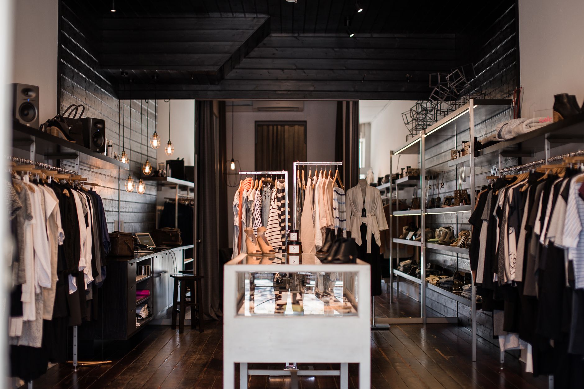 Explore o interior elegante de uma loja de moda moderna com exibições de roupas